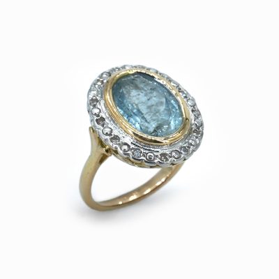 Bague ancienne en or jaune sertie d'une aigue-marine ovale entourée de diamants